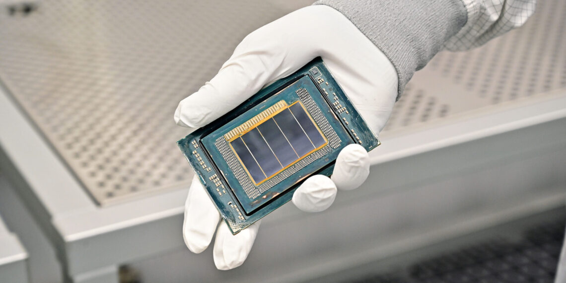 An Intel manufacturing technician holds a Clearwater Forest chip inside the cleanroom of Intel’s new Fab 52 in Chandler, Arizona, in September 2025. Fab 52 is the U.S. home to Intel 18A, where Clearwater Forest, a data center processor, will be manufactured. (Credit: Intel Corporation)